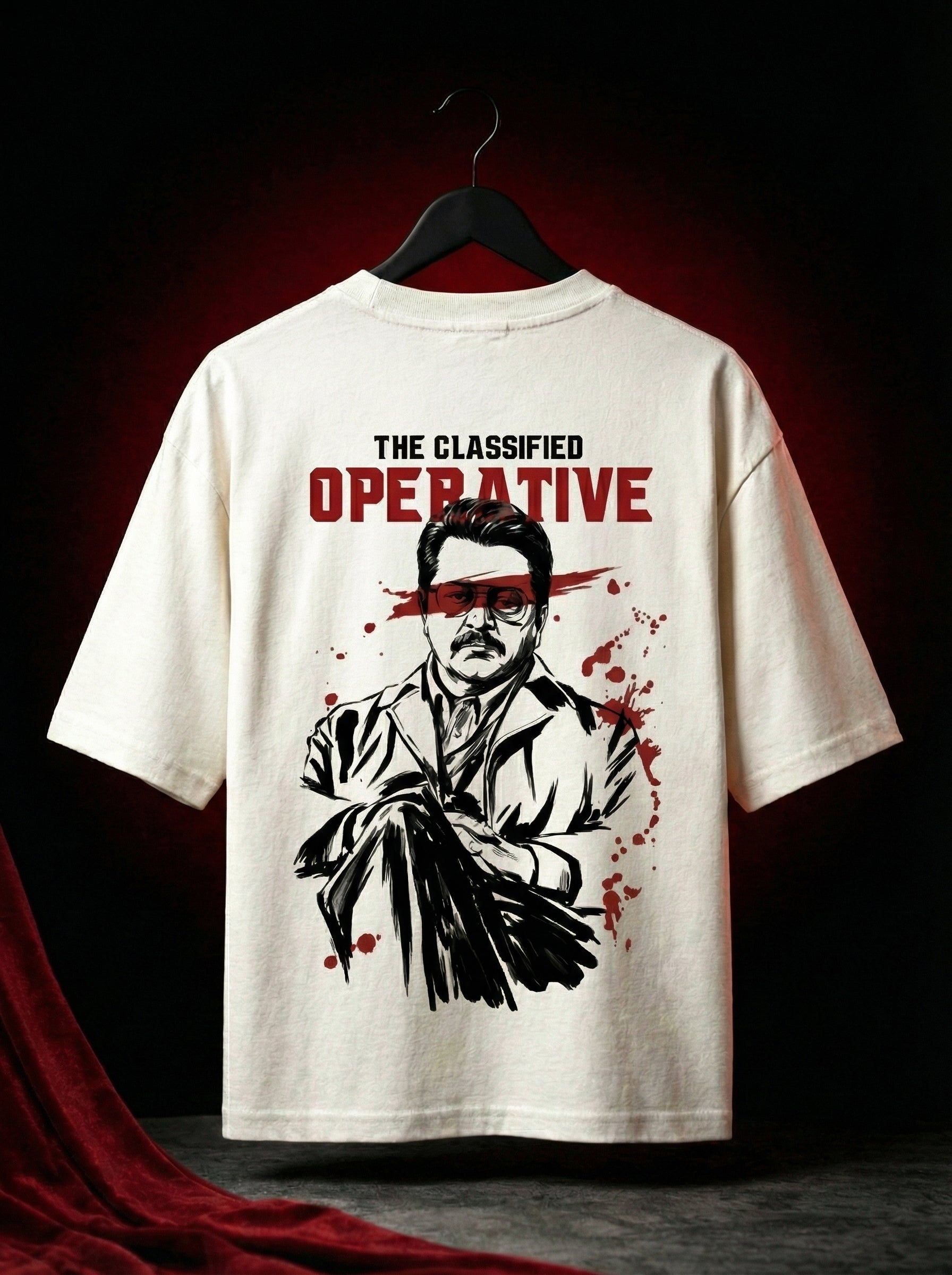Off-white oversized graphic t-shirt hanging on hanger showing full back print with bold illustrated character and red accents, cinematic spy inspired design, streetwear oversized tee India, premium cotton graphic t shirt men