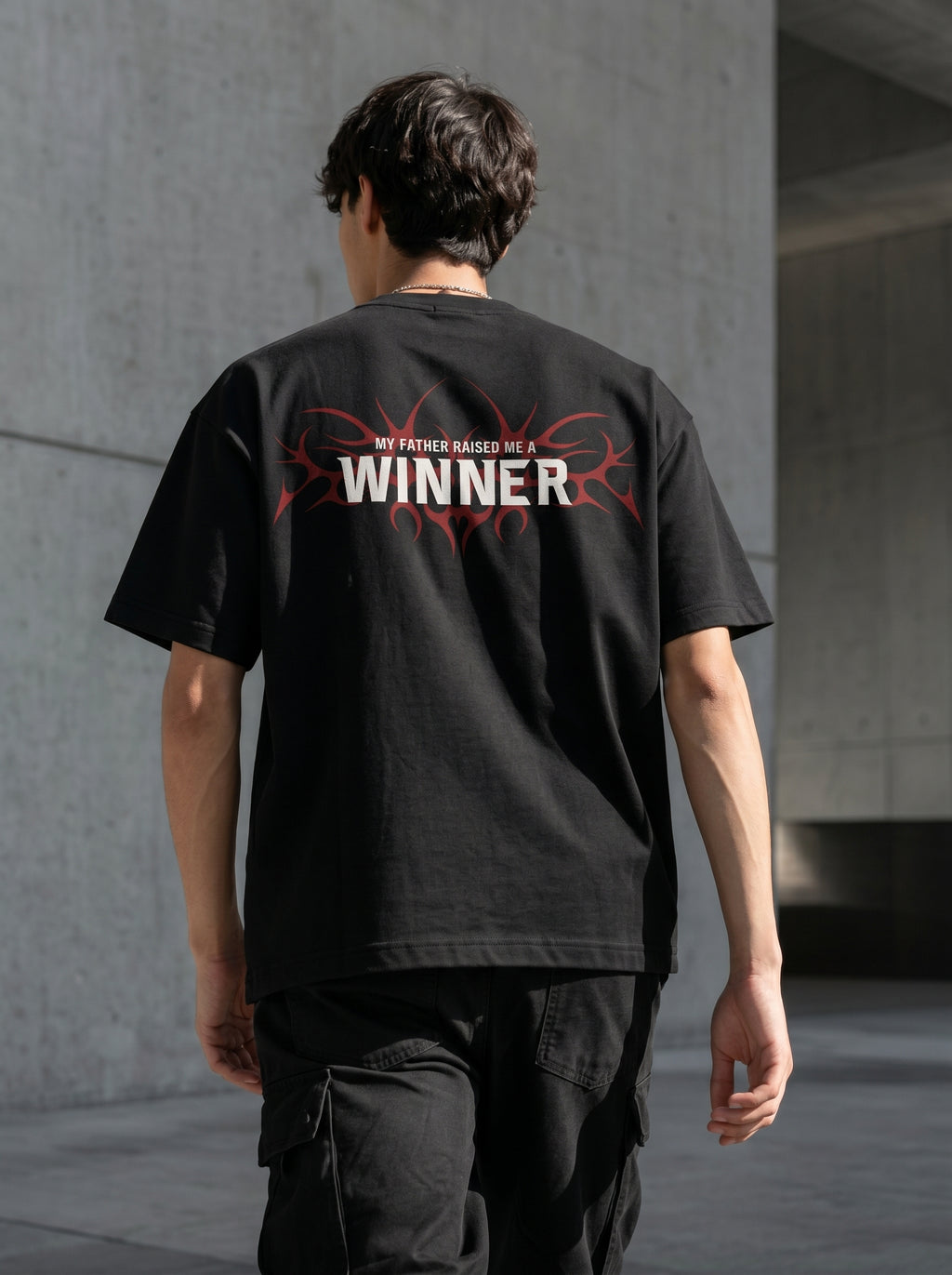 "Back view of Noverra Dhurandhar My Father Raised Me A Winner oversized boxy t-shirt with red tribal graphic, inspired by Reble song from Dhurandhar movie, Gen Z back print streetwear 2026"