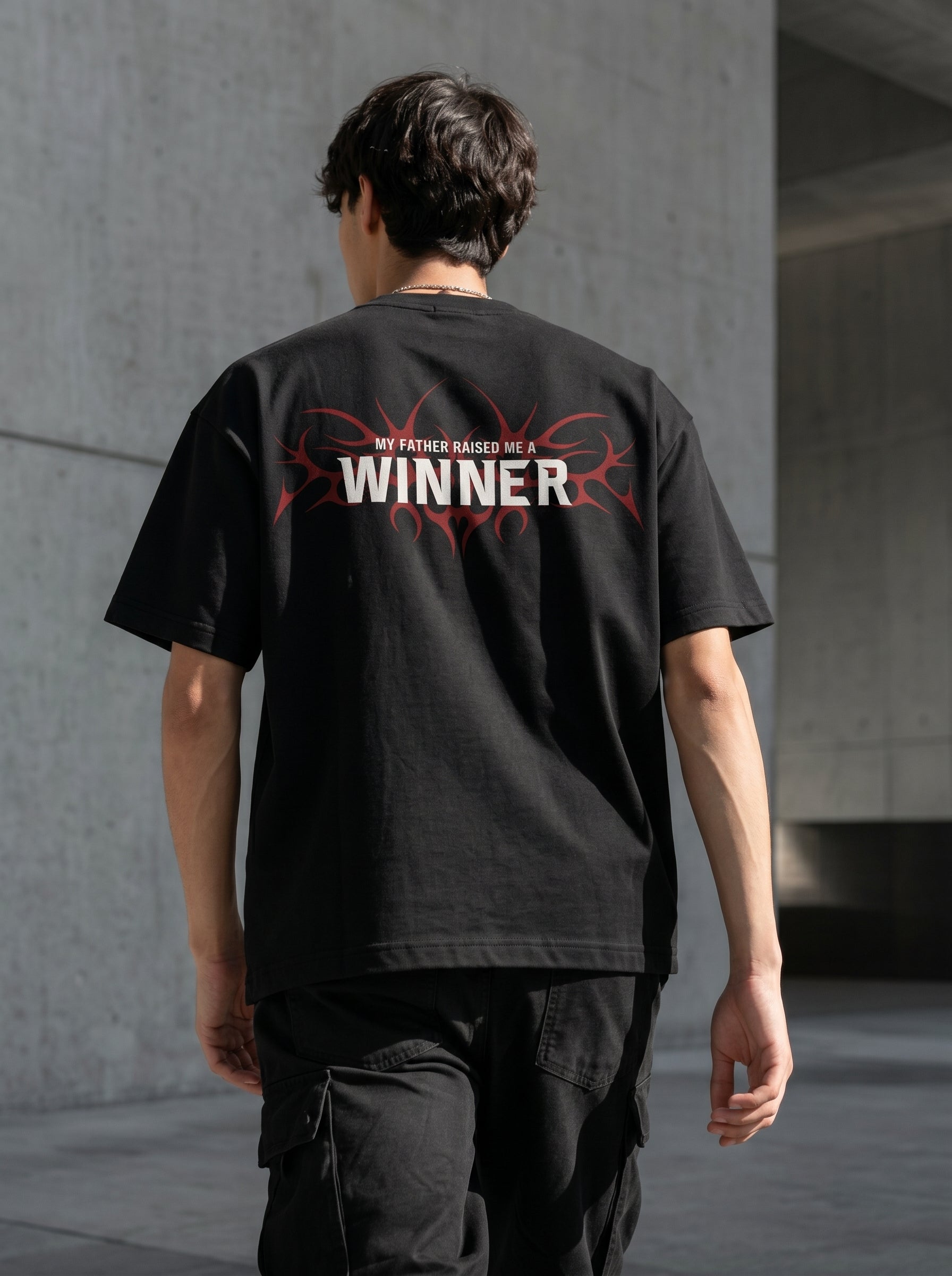 "Back view of Noverra Dhurandhar My Father Raised Me A Winner oversized boxy t-shirt with red tribal graphic, inspired by Reble song from Dhurandhar movie, Gen Z back print streetwear 2026"